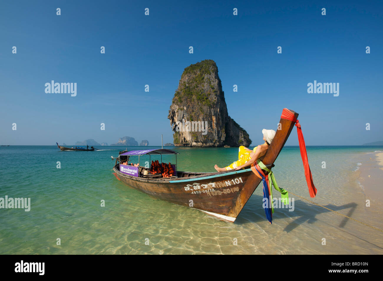 Donna relax su una barca dalla lunga coda al Porto di Laem Phra Nang Beach, Krabi, Thailandia Foto Stock