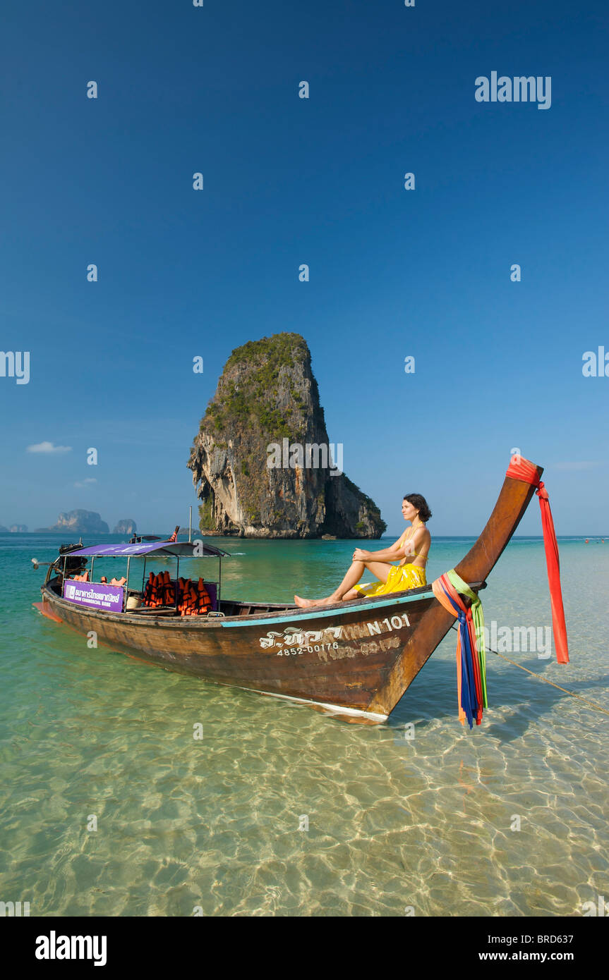 Donna relax su una barca dalla lunga coda al Porto di Laem Phra Nang Beach, Krabi, Thailandia Foto Stock