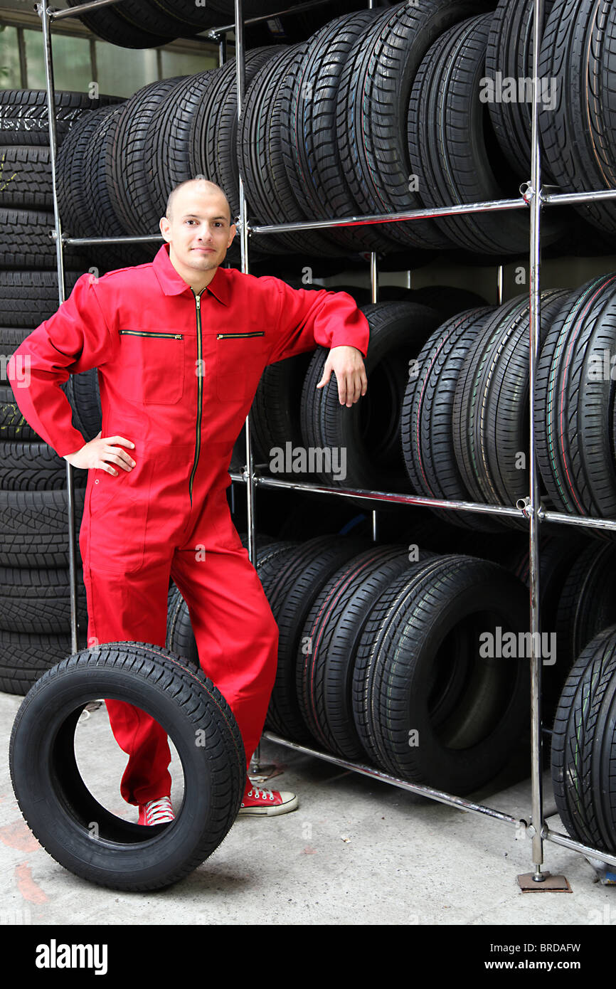 Un lavoratore motivati in un pneumatico officina. Foto Stock