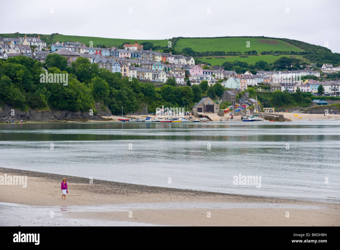 La gente a piedi lungo la spiaggia di sabbia a New Quay, Ceredigion, West Wales, Regno Unito Foto Stock