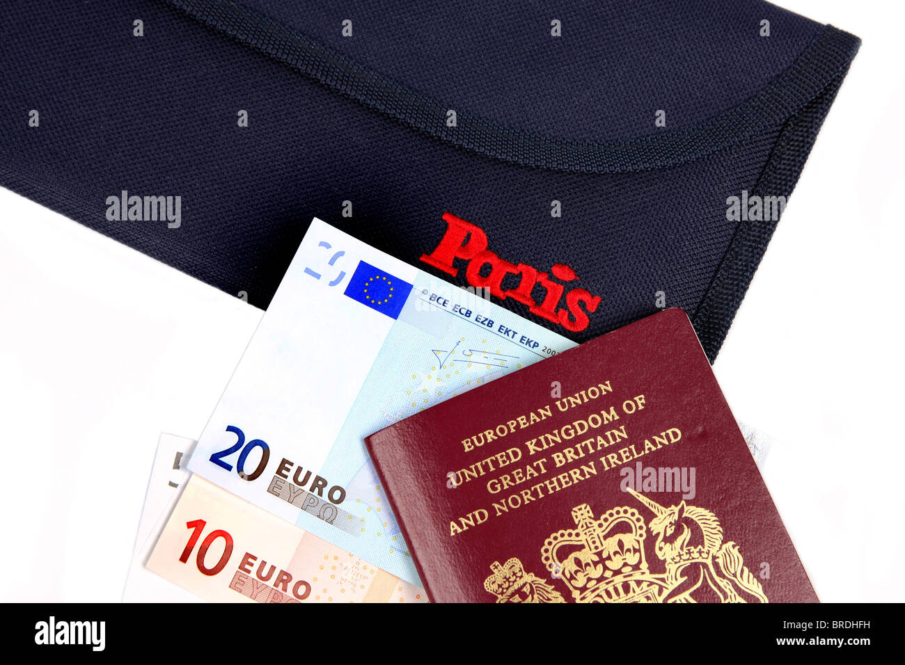 Euro denaro un passaporto britannico e una cartella la promozione di Parigi insieme contro uno sfondo bianco Foto Stock