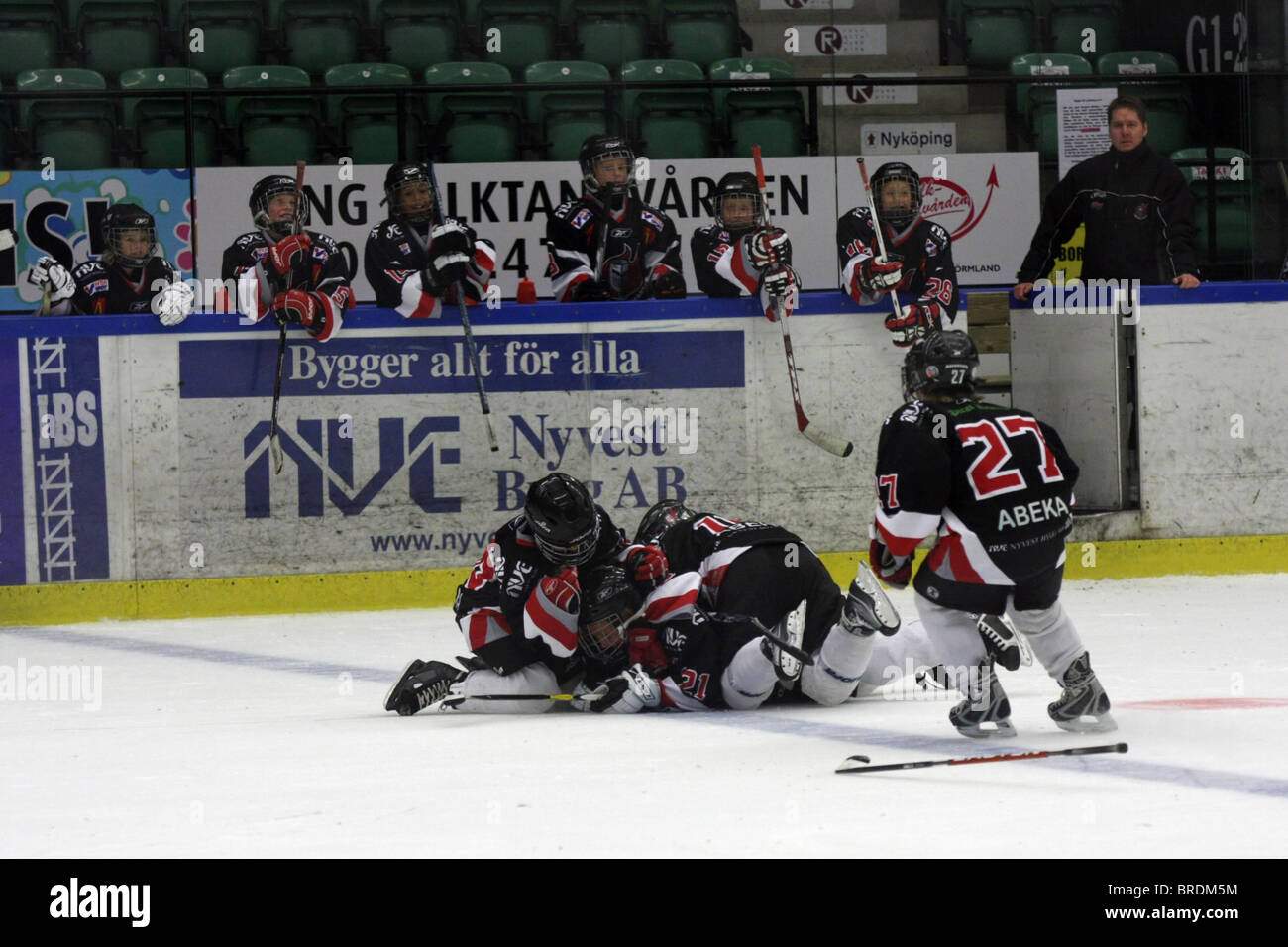 Vecchia di dieci anni i bambini a giocare hockey su ghiaccio in Svezia. Celebrando un obiettivo. Foto Stock