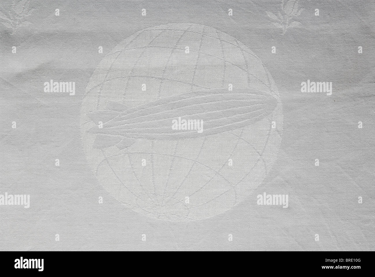 German Zeppelin Shipping Company, un set di tovaglie di seta bianca damask con decorazione della rosa e l'emblema della società nel centro di ogni pezzo nella forma di un airship sopra un globo. Diversi pezzi portano il monogramma 'Sum' del produttore. Il set è composto da un panno da tavolo (105 x 105 cm), cinque guide da tavolo (85 x 45 cm), dieci tovaglioli grandi (60 x 60 cm.) e quattro tovaglioli più piccoli (50 x 50 cm). Anche un tovagliolo di lino con una 'Z' sopra un dirigibile nel centro (58 x 40 cm). Il numero 130 per l'aeronave LZ 130, 'Graf Zeppelin II' è tessuto nei quattro tovaglioli più piccoli. Th, Foto Stock