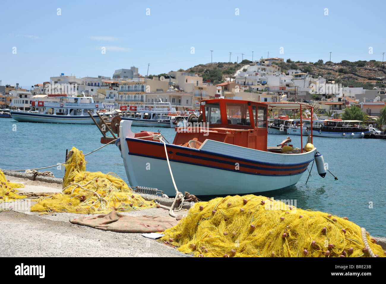 Il giallo delle reti da pesca e la pesca in barca ormeggiata nel porto di elounda, Creta, Grecia Foto Stock
