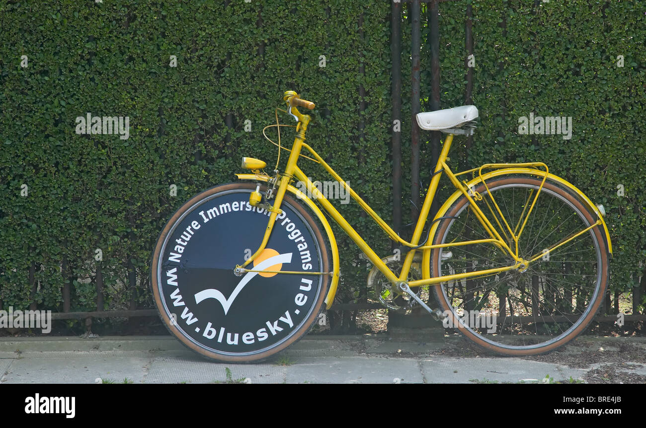 Un giallo bicicletta pubblicità www.bluesky.eu parcheggiato nel Parc du Cinquantenaire (Jubilee Park) a Bruxelles, in Belgio Foto Stock