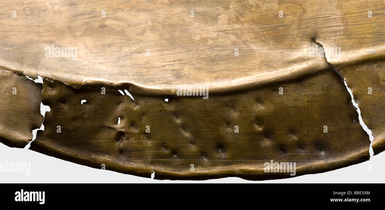 Un greave romano con iscrizione, 2nd/3rd secolo d.C. ottone Goffrato. Decorato con poco verde con una nervatura centrale leggermente sollevata. Bordi sfalsati con fori per il fissaggio degli anelli delle cinghie. Un attrezzo sulla parte superiore per il fissaggio di una cerniera per la protezione ginocchia. La scritta "RVG" sul bordo sinistro con un segno a forma di "T". Lunghezza 33 cm. Peso 195 g.. Il metallo è molto ben conservato, crepe all'estremità inferiore e sui lati. Collezione Axel Guttmann (R 185/AG 712) Turnierrüstungen - Sammlung Axel Guttmann', vol. 4, Magonza 1997, pag. 129 fig. 83 Piastra XV con interpretazione, Foto Stock