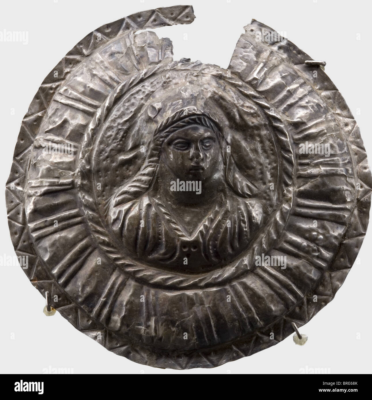Una falera d'argento romana, 2nd secolo d.C. falera d'argento, o medaglione decorativo, con un mezzitratti femminile in rilievo. Riccamente decorato con un bordo a filo, triangoli, modanature arrotolate e puntine. Iscrizione illeggibile(?) in semicerchio sopra il ritratto femminile. Diametro 9 cm. Peso 13 g. Il dorso è stato parzialmente stabilizzato con fibra di vetro e resina, difetti sul bordo superiore. Axel Guttmann Collection (nessun numero di inventario). Provenienza: Giessner Coin Merchant, Monaco, lotto 2514, nessuna data. Storico, storico, persone, mondo antico, anc, Foto Stock