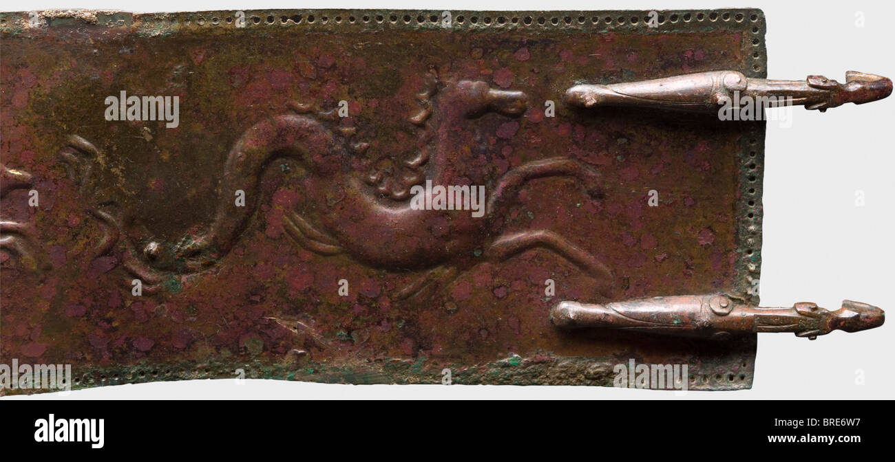 Una cintura italiana, del 4th secolo a.C. UNA cintura in bronzo con bordo perforato che trattiene dei piccoli perni in bronzo a testa tonda per il materiale di supporto. Due cicale stilizzate rivettate ad un'estremità come ganci di fissaggio, e tre file di doppi fori per ricevere i ganci sull'altra estremità. La cintura è decorata con un mostro marino goffrato con il corpo di un cavallo, stracci correndo, e cavalli. Lunghezza 79 cm. Larghezza 7,5 cm. Patina nobile marrone rossastra che mostra la superficie metallica in luoghi. La schiena è stata stabilizzata in luoghi, ed è montata su un supporto in legno. Axel Gu, Foto Stock