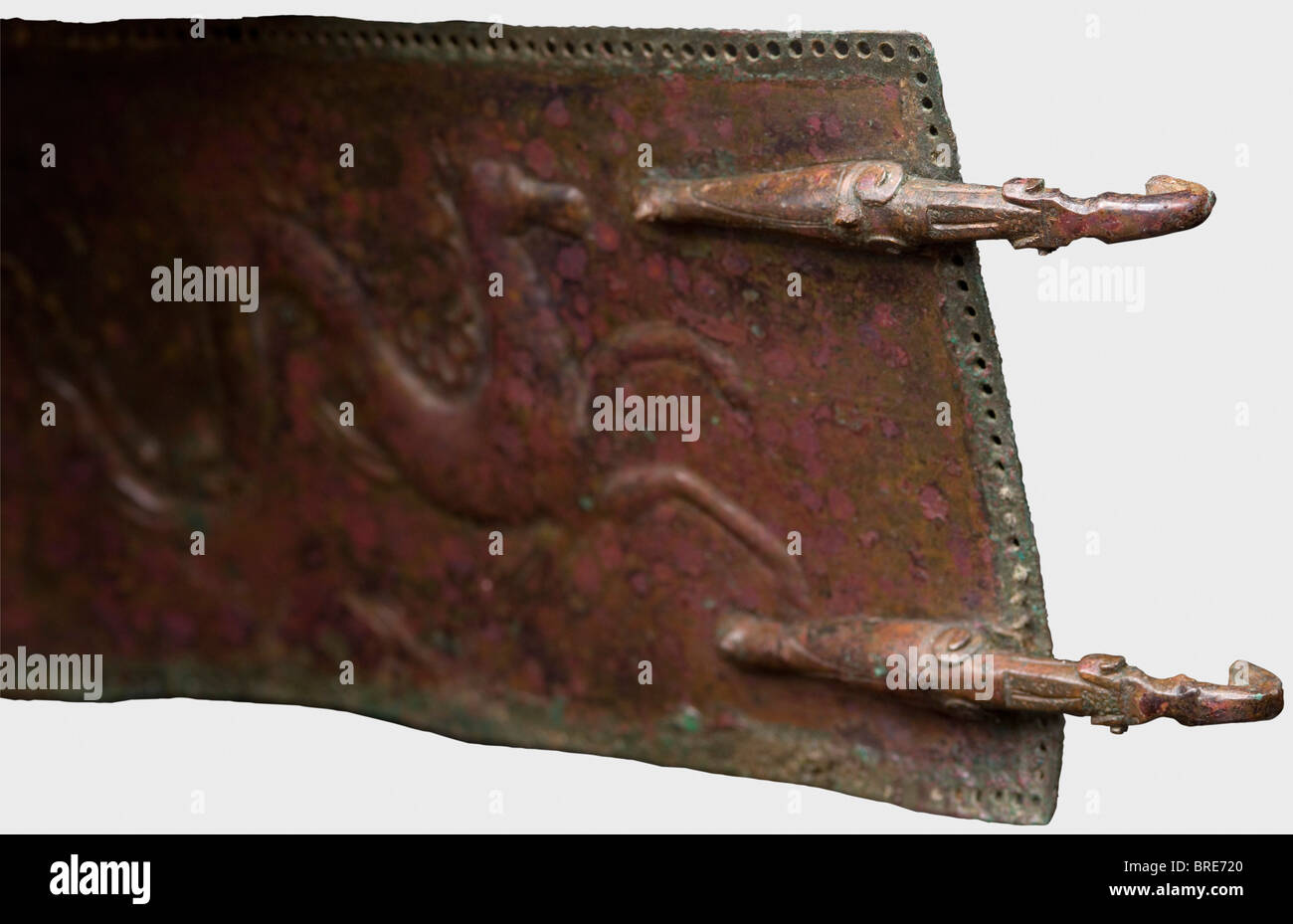 Una cintura italiana, del 4th secolo a.C. UNA cintura in bronzo con bordo perforato che trattiene dei piccoli perni in bronzo a testa tonda per il materiale di supporto. Due cicale stilizzate rivettate ad un'estremità come ganci di fissaggio, e tre file di doppi fori per ricevere i ganci sull'altra estremità. La cintura è decorata con un mostro marino goffrato con il corpo di un cavallo, stracci correndo, e cavalli. Lunghezza 79 cm. Larghezza 7,5 cm. Patina nobile marrone rossastra che mostra la superficie metallica in luoghi. La schiena è stata stabilizzata in luoghi, ed è montata su un supporto in legno. Axel Gu, Foto Stock