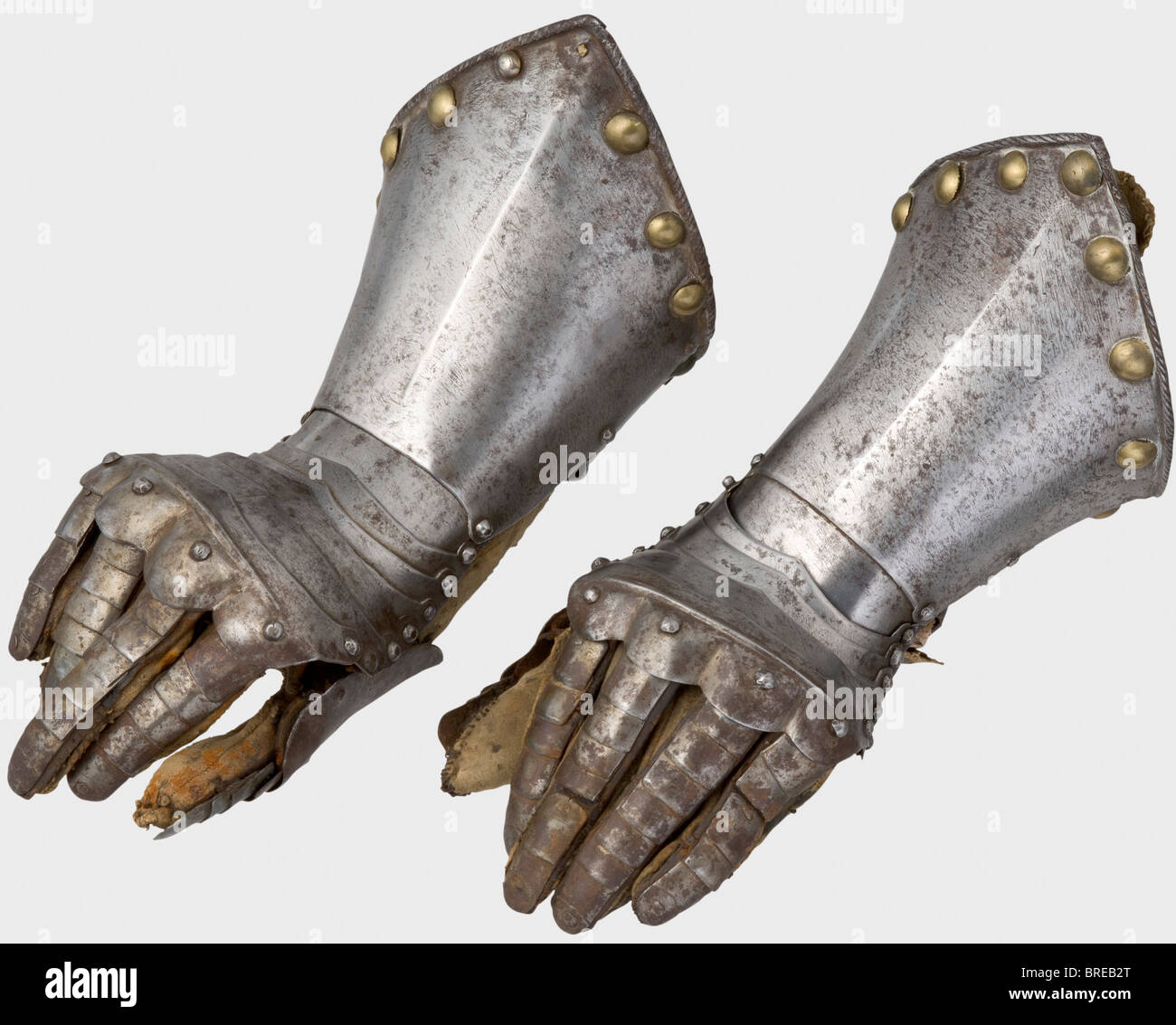 Un paio di guanti fingered, Germania o Fiandre, circa 1600 Metacarpus di sei lames. Protezione del fuso a snodo bombata con piastre dei denti articolate sovrapposte (una sostituita, due mancanti). Difese con pollice a riscoperta con lames sovrapposti. Polsini a punta rigati con bordi arrotondati e arrotondati. Grandi rivetti decorativi in ottone lungo il perimetro (due rivetti mancanti). Guanti originali cuciti con fodera in pelle di colore naturale, camoscio (segni di età, ciascuno danneggiato al polso). Lunghezza di ogni 34 cm. Storico, storico, 17th secolo, armi difensive, armi, Foto Stock