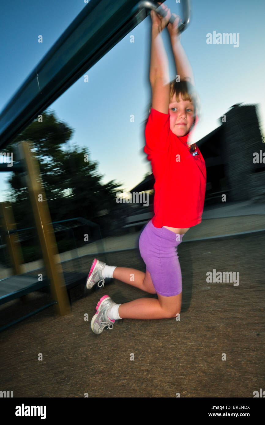 7 anno vecchia ragazza giocando sul cursore a parco pubblico. Foto Stock