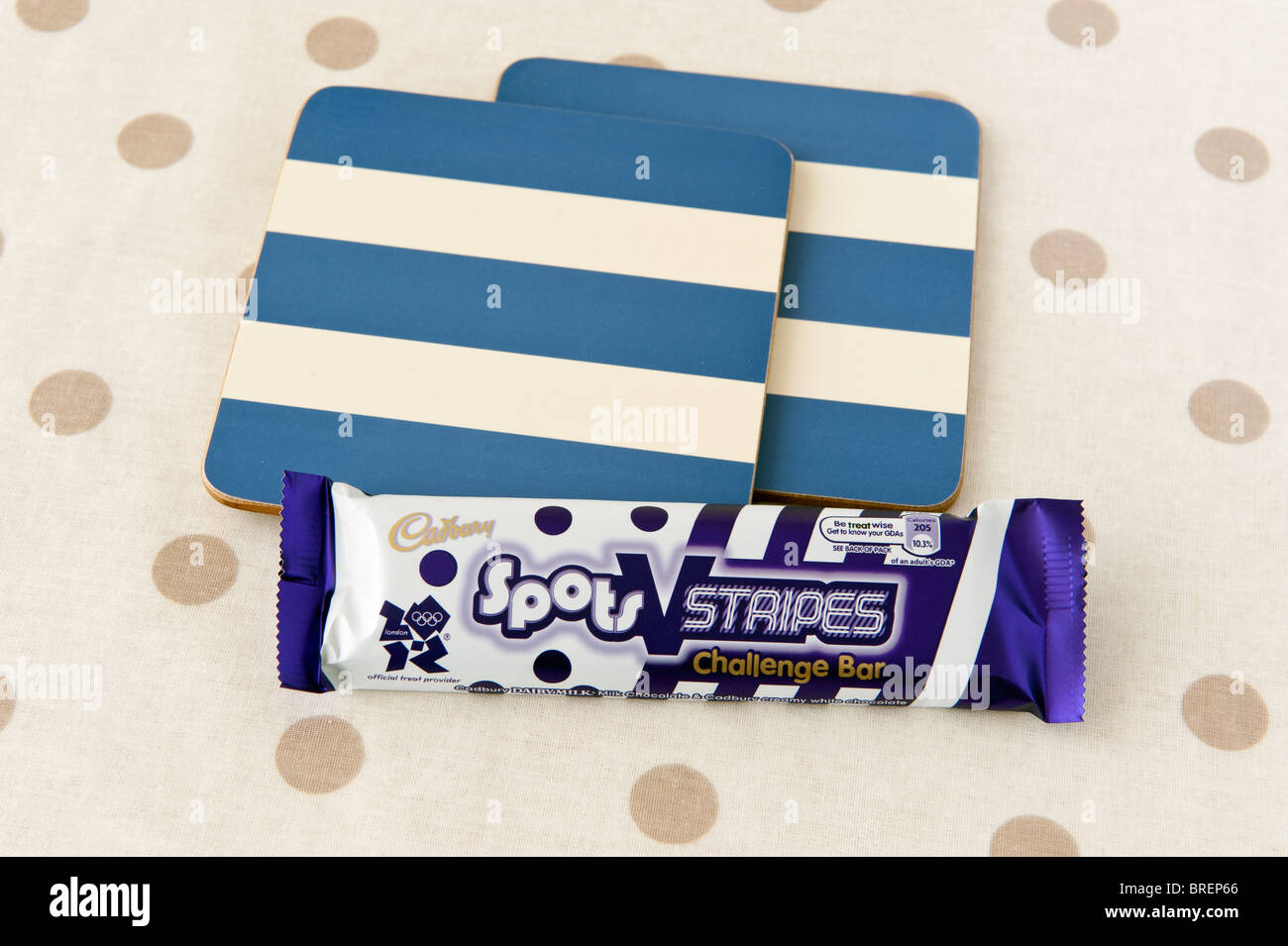 Macchie di Cadbury e strisce della barretta di cioccolato e 2 blu e crema di montagne russe a strisce su un color crema e marrone e tappetino macchiato Foto Stock