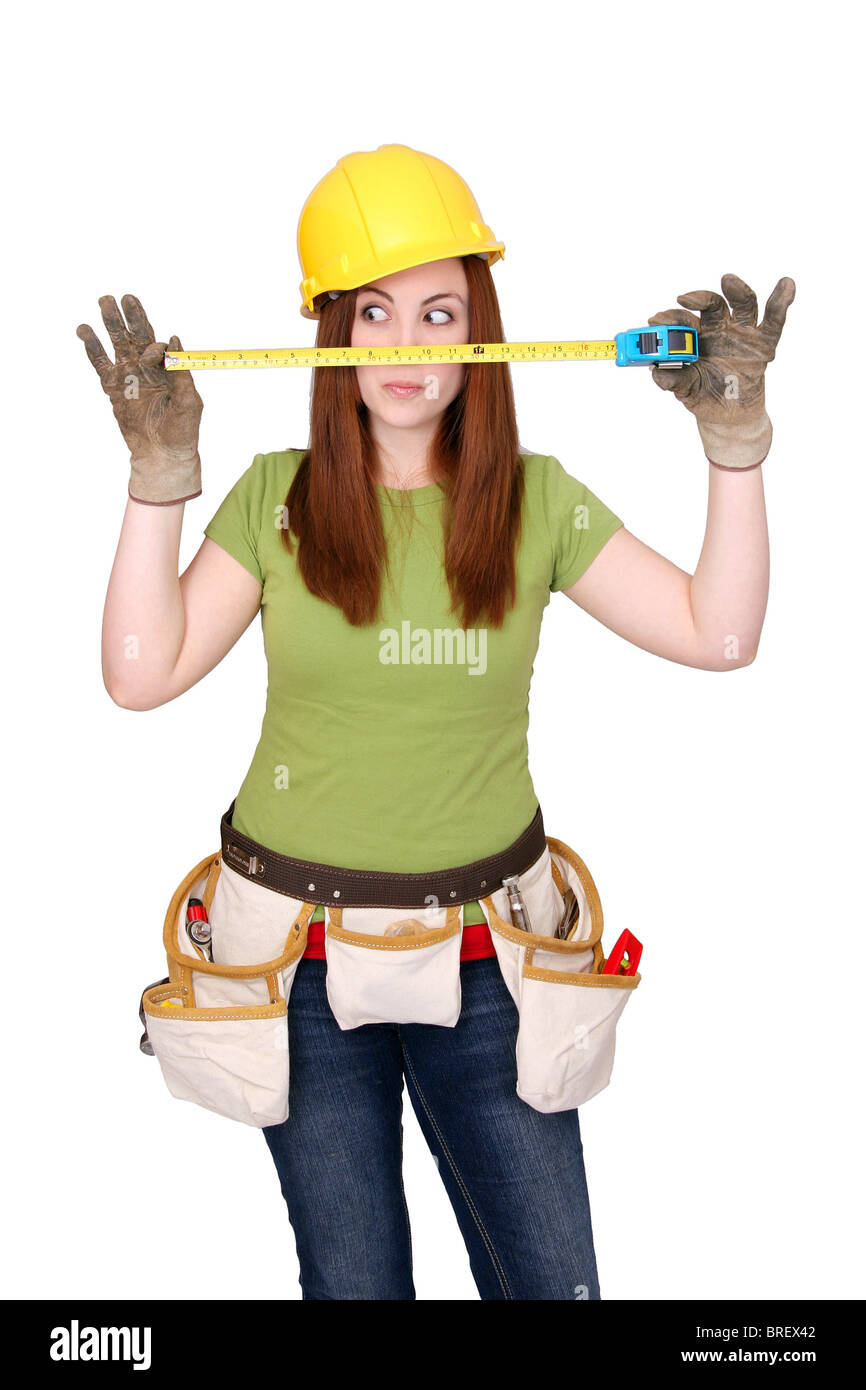 Bella espressiva lavoratore edile donna con hardhat e utensili per la lavorazione su bianco Foto Stock