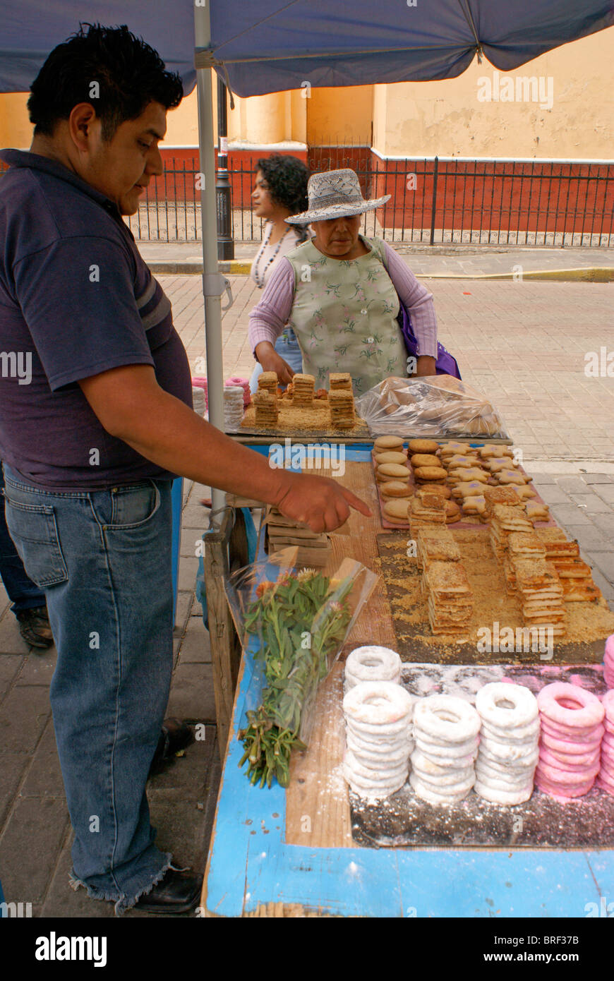 Donna dolci di acquisto da un venditore ambulante in Cholula, Puebla, Messico Foto Stock