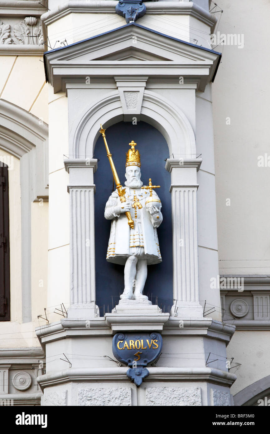 Statua dell'Imperatore Carlo V, che indossa una corona e la tenuta di un globo imperiale e scettro, in una facciata con i fili per la protezione Foto Stock