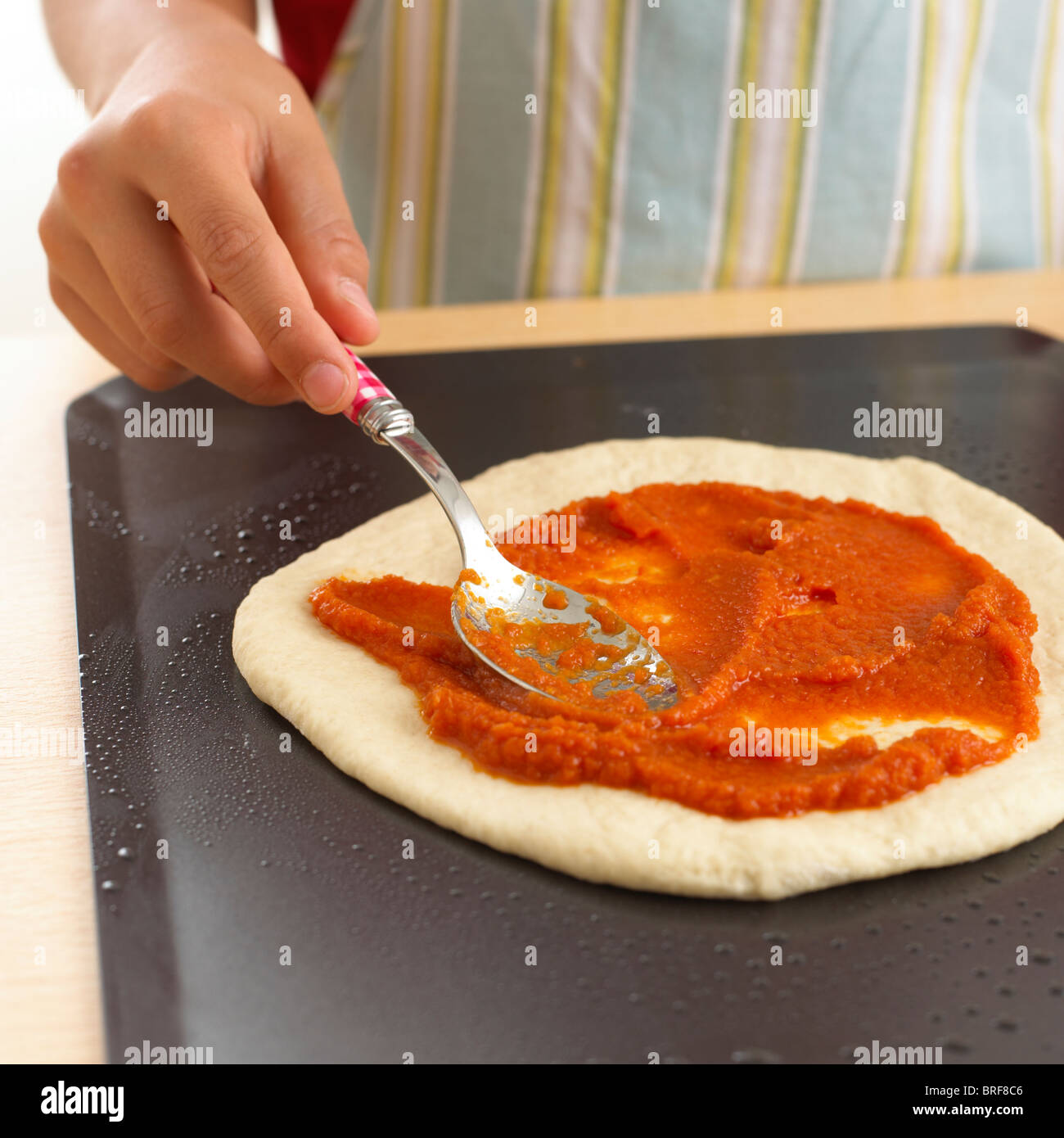 Donna diffusione di concentrato di pomodoro a base di pizza Foto Stock