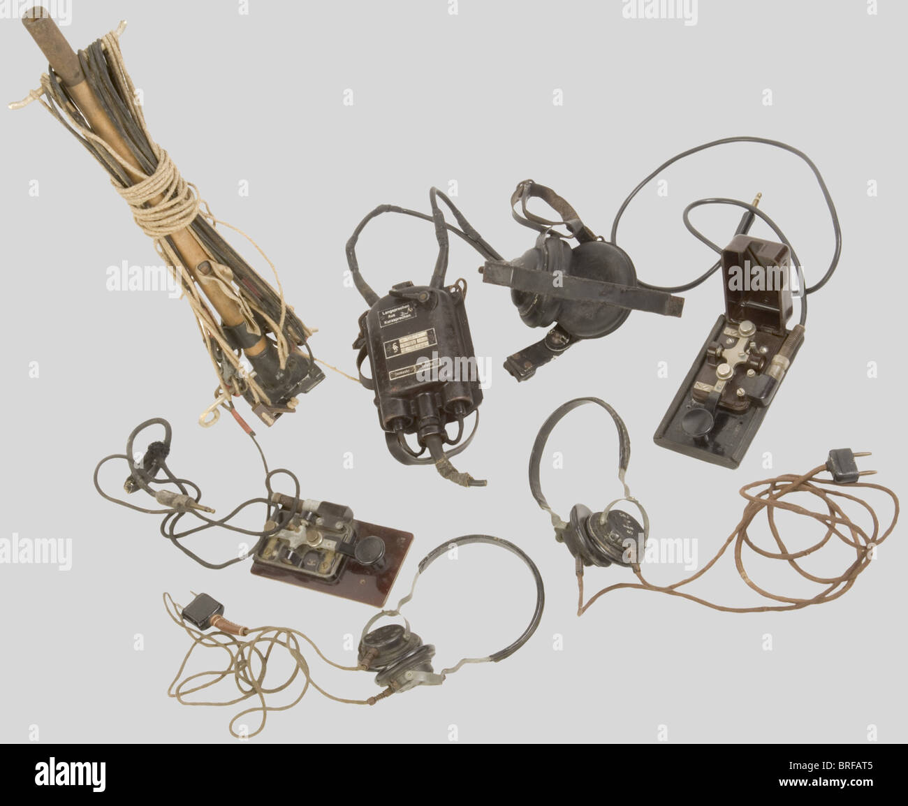 Un gruppo di apparecchiature radio Wehrmacht, compreso un palo radio di trasmissione/ricezione con antenna, in legno e alluminio grigio, completo di cavi e bollini di consegna. Due encoder morse in metallo con base in bachelite, uno senza coperchio, completo di cavi e spine/prese. Due set di cuffie complete di prese e cavi. Trasmettitore/ricevitore Siemens per artiglieria costiera, inclusi auricolari neri larghi, cinghie di ritegno in pelle, fibbie metalliche, microfono mancante, custodia ventrale in metallo nero con cinghia di fissaggio, completo di bottoni e prese, Foto Stock