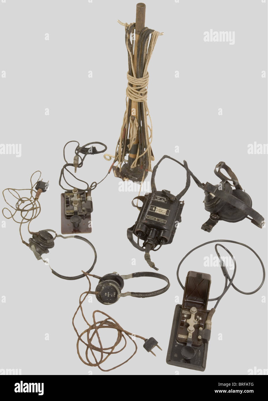 Un gruppo di apparecchiature radio Wehrmacht, compreso un palo radio di trasmissione/ricezione con antenna, in legno e alluminio grigio, completo di cavi e bollini di consegna. Due encoder morse in metallo con base in bachelite, uno senza coperchio, completo di cavi e spine/prese. Due set di cuffie complete di prese e cavi. Trasmettitore/ricevitore Siemens per artiglieria costiera, incluso casco largo, auricolari neri, cinghie di ritegno in pelle, fibbie metalliche, microfono mancante, custodia ventrale in metallo nero con cinghia di fissaggio, completo di pulsanti AN, Foto Stock