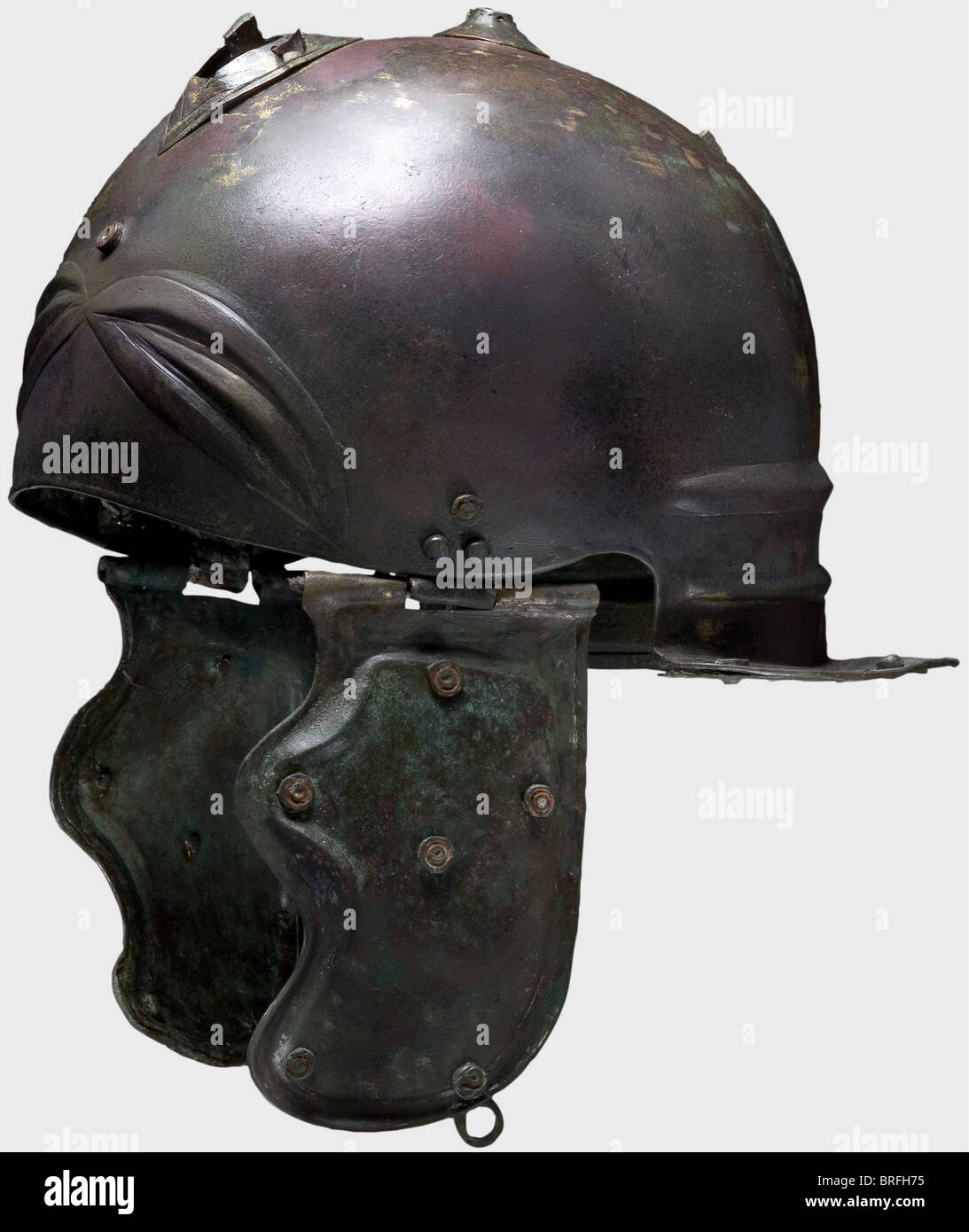 Casco romano tipo Weisenau/Guttmann, prima metà del i secolo d.C. Bronzo, cranio emisferico con tre sopracciglia ellitticamente scolpite sulla fronte e un elaborato cresta di basi ellittiche e circolari saldate, con fori per perni inseriti lateralmente, sulla corona. I resti di un ornamento a casco a pettine sono stati conservati separatamente. I pezzi di guancia curvi hanno bordi scolpiti, anelli di cinghia rivettati, e cerniere tubolari, e ciascuno è decorato con sei occhi ornamentali rossi-smaltati(?)rivettati, con altri sulla fronte, le stanghette, e, diritti aggiuntivi-giochi-non disponibili Foto Stock