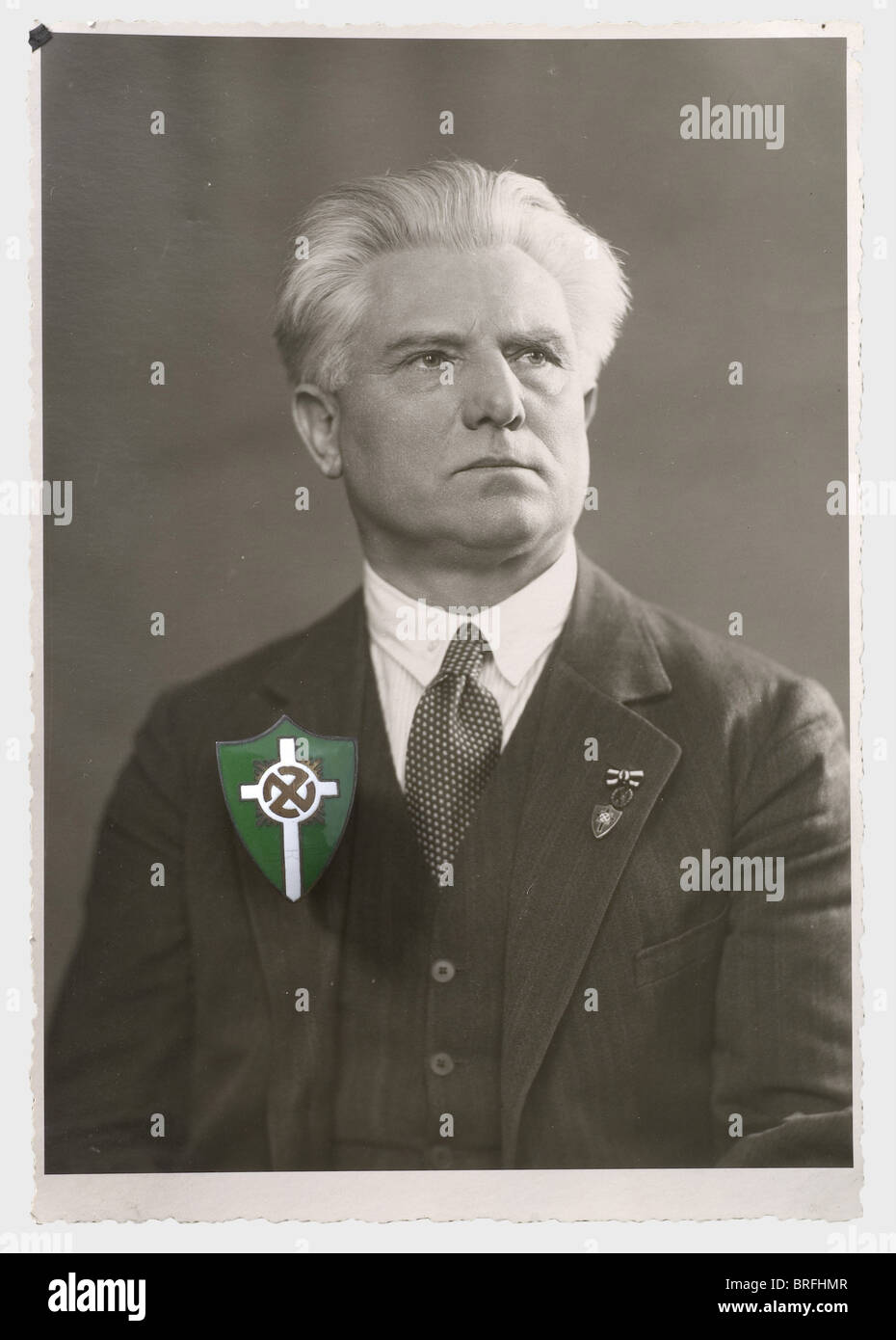 Artur Dinter - Chiesa Del Popolo tedesco, foto, badge, documenti e giornali. Monogramma personale smaltato verde-bianco della Chiesa Tedesca Del Popolo, con ritratto di Dinter indossando il distintivo sul suo lapel. 15 foto ritratte con inchiostro segnano le figure principali della Chiesa Del Popolo tedesco, congiuntate su passepartout, incorniciate, 50 x 40 cm. Due file con edizioni hardback della rivista 'die religiöse Revolution - Kampfblatt der deutschen Volkskirche E.V. - Kampfbund', Vol. 1/1934 fino al Vol. 4/1937. Anche i documenti e la corrispondenza relativi a , Foto Stock