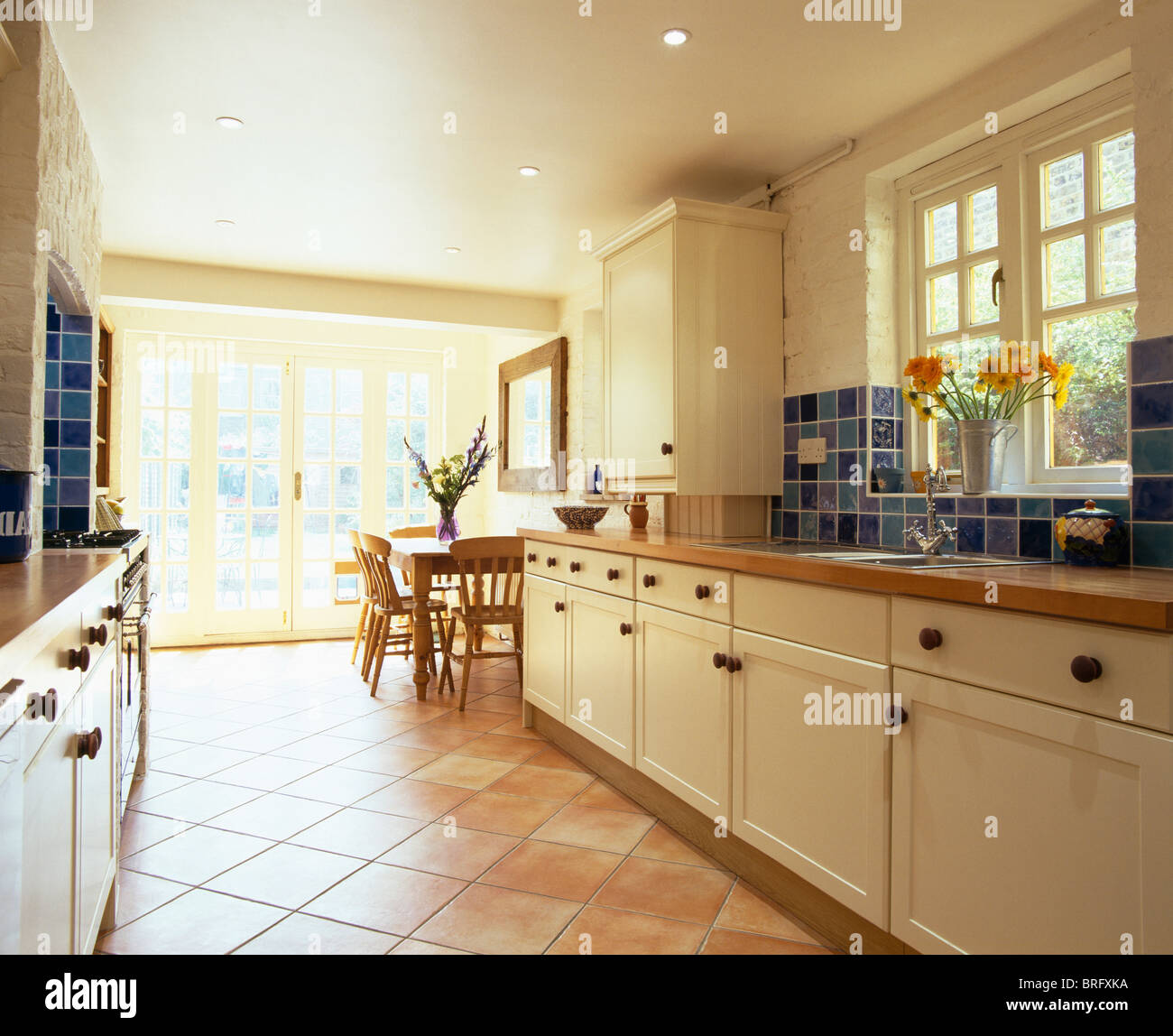 Pavimento in piastrelle di cotto nella cucina a pianta aperta la sala da  pranzo la prolunga con la panna montata e unità di piastrelle blu  splash-back Foto stock - Alamy