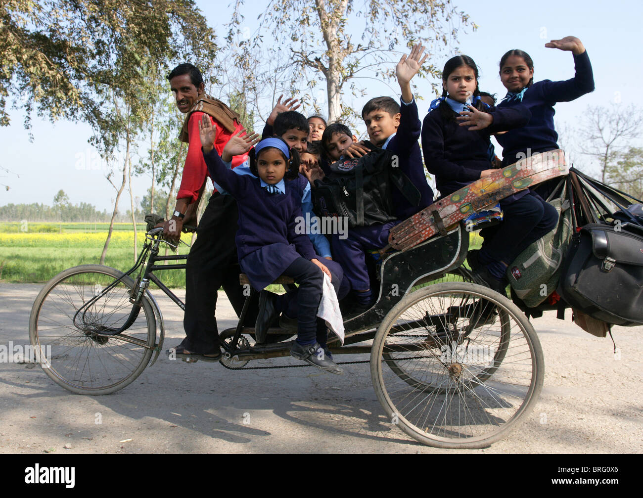 Scolari in sella a casa da scuola con un risciò bicicletta. Uttar Pradesh, India Foto Stock