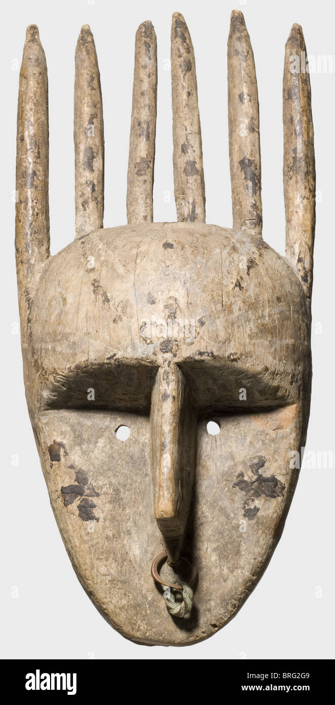 Una maschera Bambara, Mali, circa 1900. Maschera in legno fortemente stilizzata con tracce di finitura scura. Naso fortemente enfatizzato decorato con anelli di rame. Sei avvisatori acustici in alto. Gli occhi sono semplicemente indicati come due fori rotondi, la bocca punta verso il basso. Una coppia di fori di fissaggio su ciascun lato. Segni di usura e alcune crepe di espansione. Altezza 44 cm. Storico,storico,1900,XX secolo,XIX secolo,belle arti,arte,tribù,tribù,tribali,africane,africane,etniche,etniche,esotiche,wodden,sculture,figure,figure,oggetti,diritti aggiuntivi-non disponibili Foto Stock
