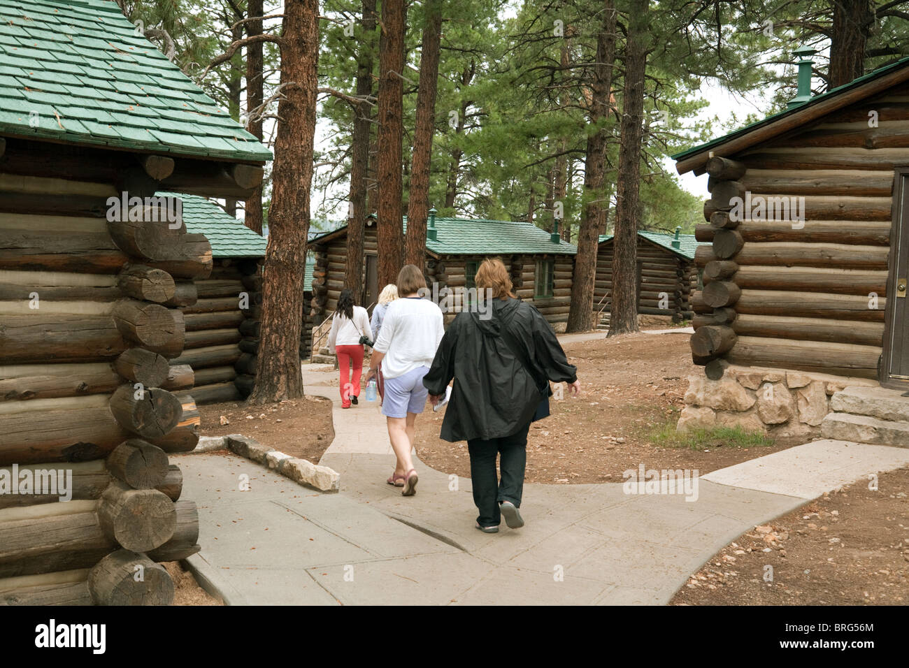 Un turista famiglia andando indietro ai loro log cabin, Grand Canyon Lodge, North Rim, Arizona USA Foto Stock