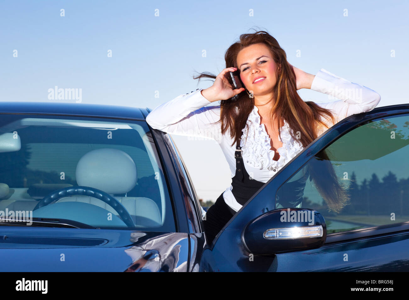 Giovane imprenditrice parlando al telefono alla sua auto. Foto Stock