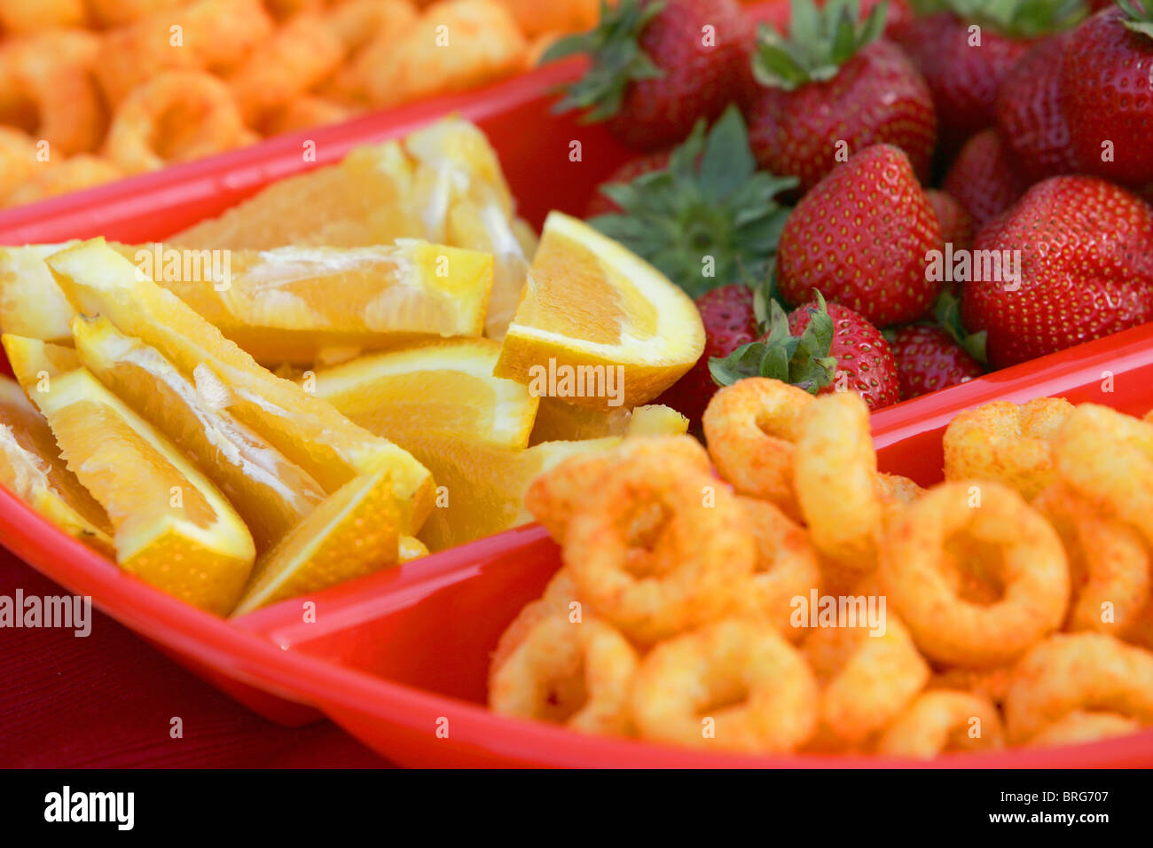 Close-up di fragole, le fette di limone e riccioli di formaggio in un recipiente diviso. formato orizzontale. Foto Stock