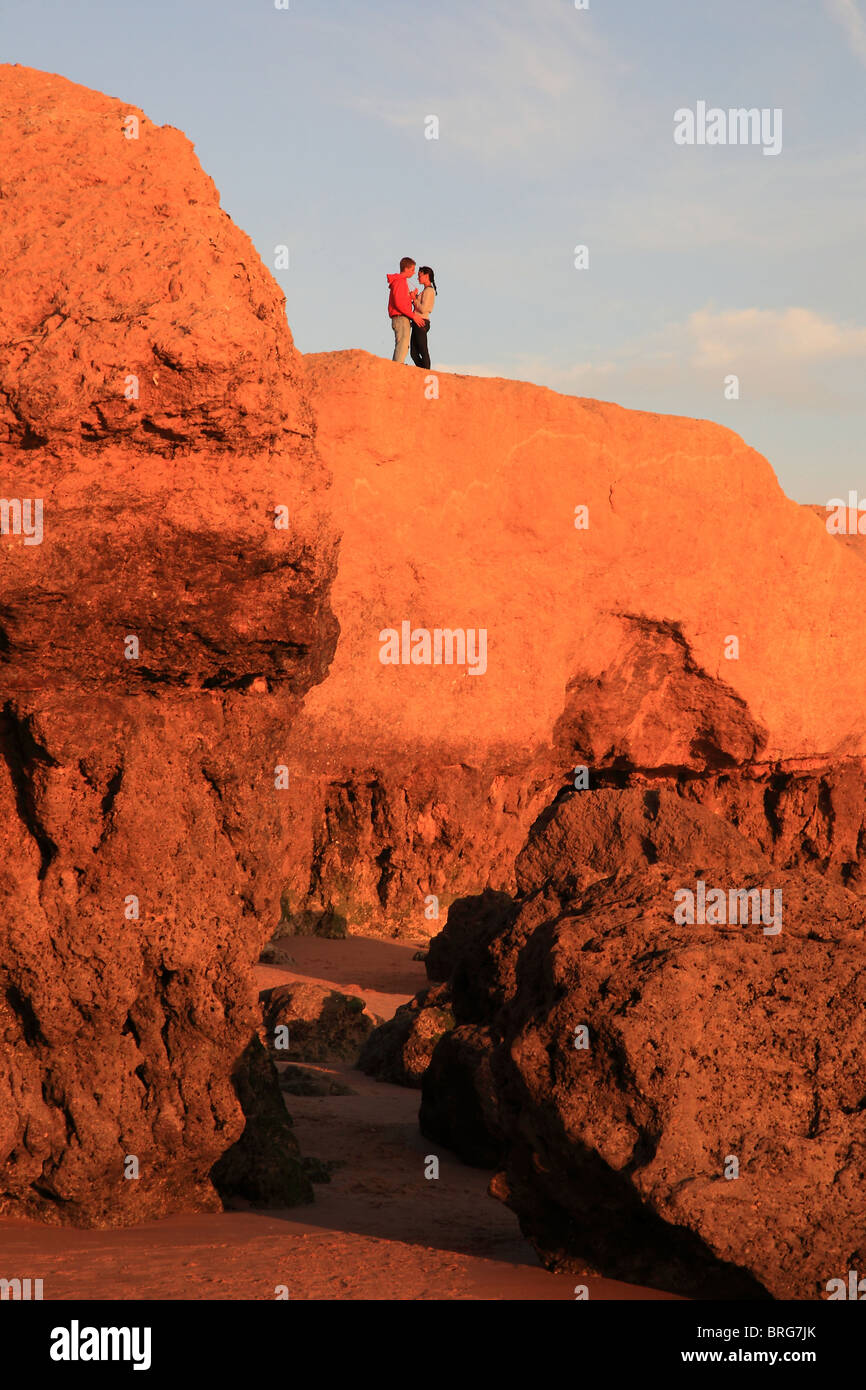 L uomo e la donna sulla sommità della roccia in Praia de Gale, Algarve, PORTOGALLO Foto Stock