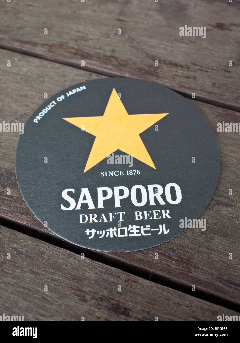 Messa a fuoco selettiva su una birra Sapporo tappetino su di un tavolo di legno Foto Stock