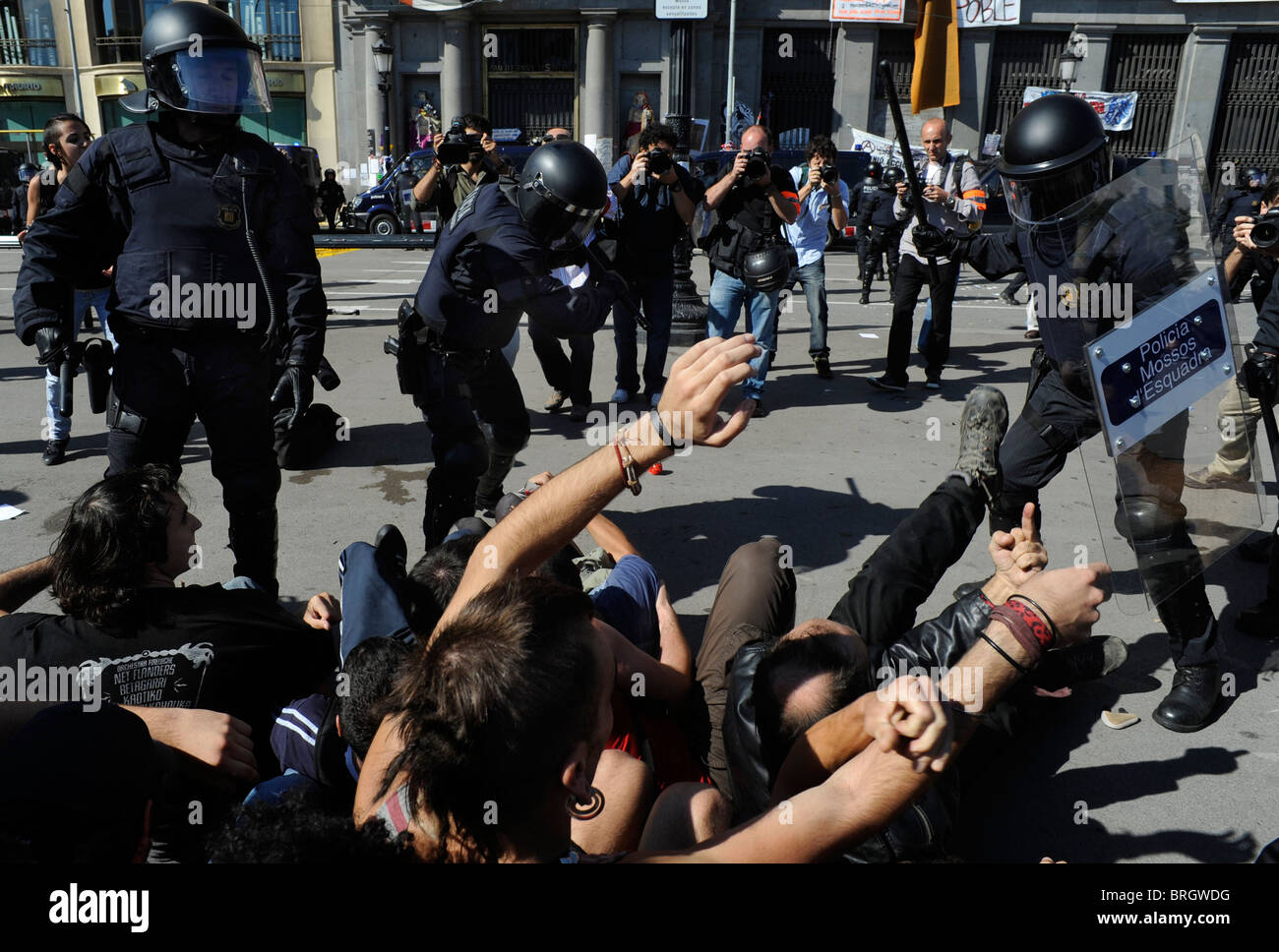 Anti Riot Police battendo i dimostranti anti sistema in scontri presso il centro della città durante lo sciopero generale. Barcellona.Spagna. Foto Stock