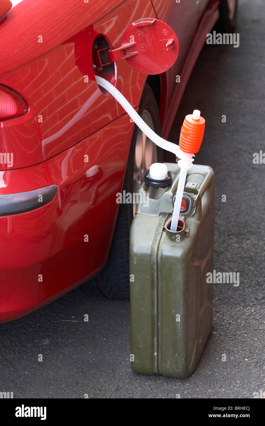 Il rifornimento di auto da Jerry carburante può con syphon Foto Stock