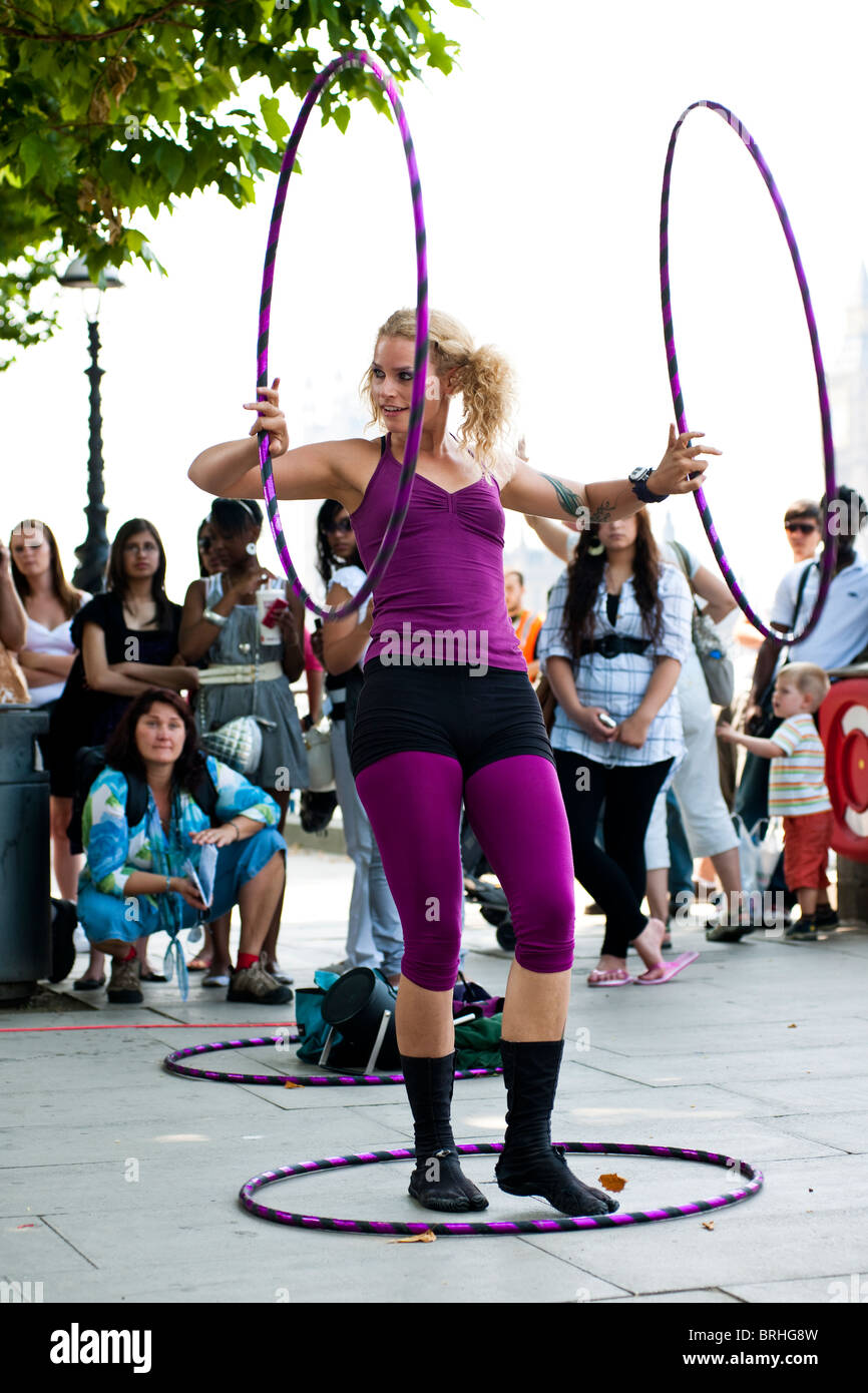 Hula Hooper Lisa Lotti esegue su London South Bank con il Big Ben in background. Foto Stock