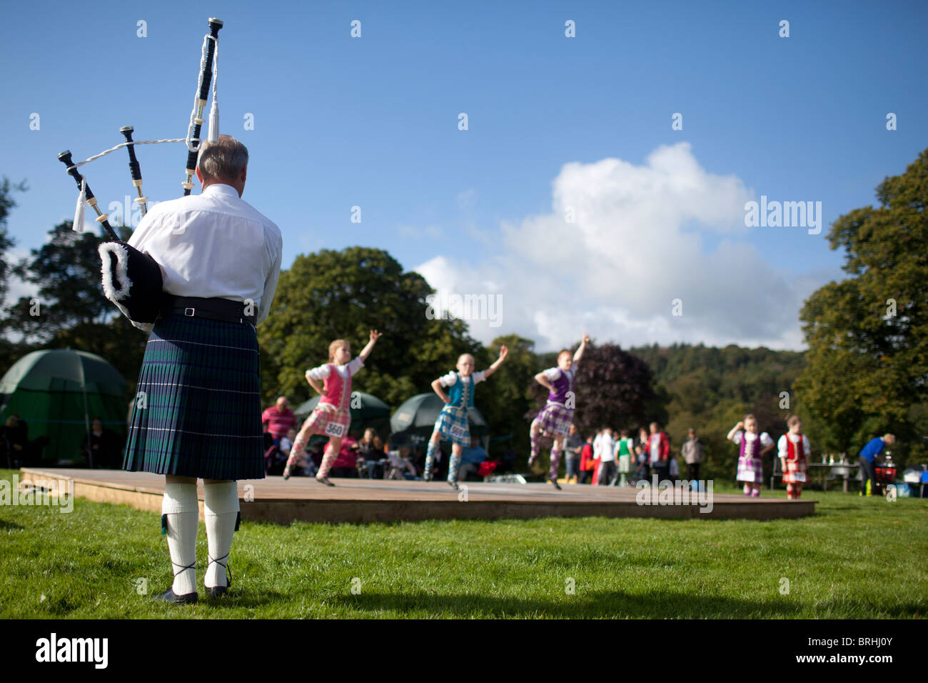 Un uomo è la riproduzione di cornamuse per giovani ballerini delle highland, Peebles Giochi delle Highland, Scotland, Regno Unito Foto Stock