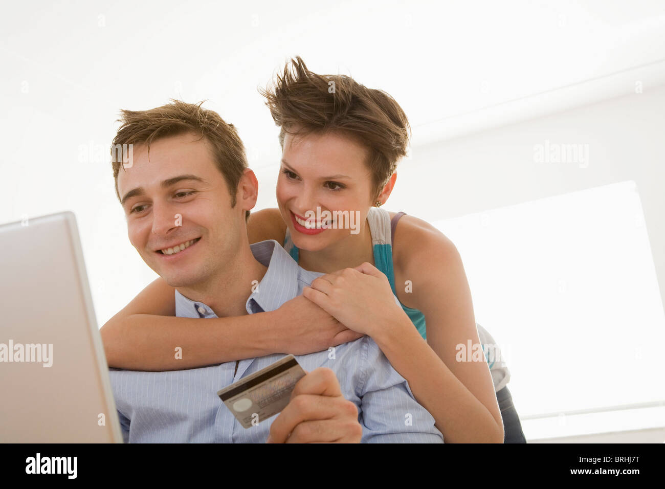 Coppia giovane con carta di credito e uso del computer Foto Stock