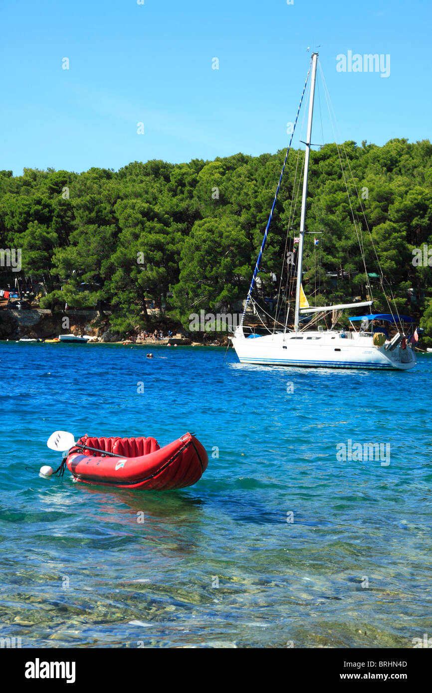 Yacht a vela e canoa gonfiabile in Bijar Bay nei pressi di Osor villaggio sull isola di Cres, Croazia Foto Stock