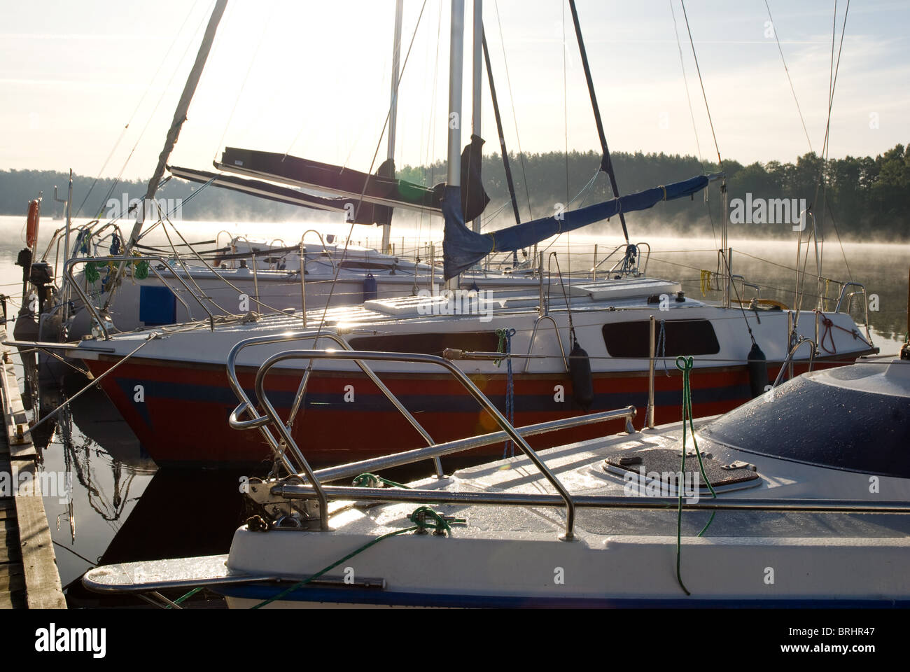 La nebbia e la brina sulle barche ormeggiate nella luce solare Foto Stock