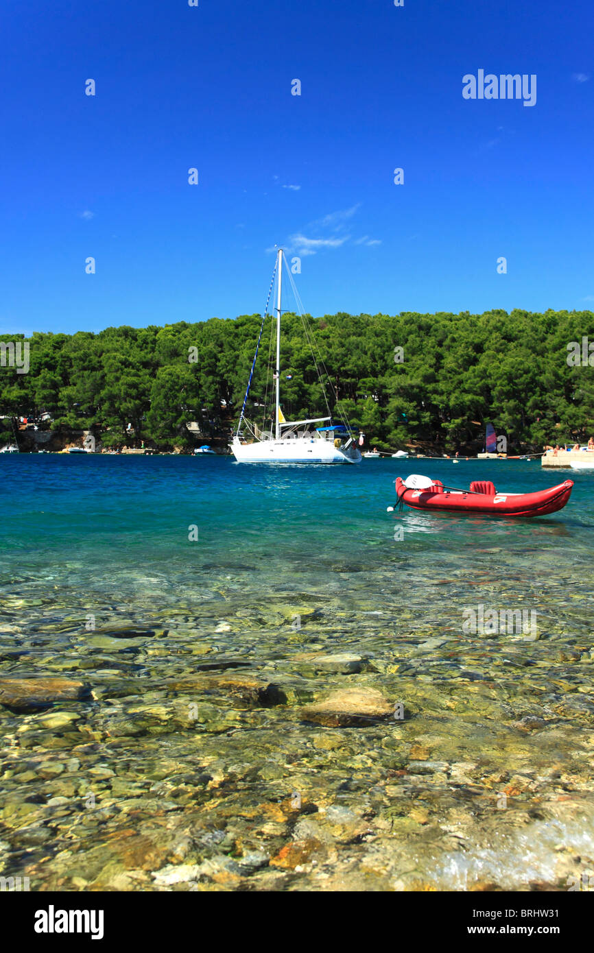 Yacht a vela e canoa gonfiabile in Bijar Bay nei pressi di Osor villaggio sull isola di Cres, Croazia Foto Stock