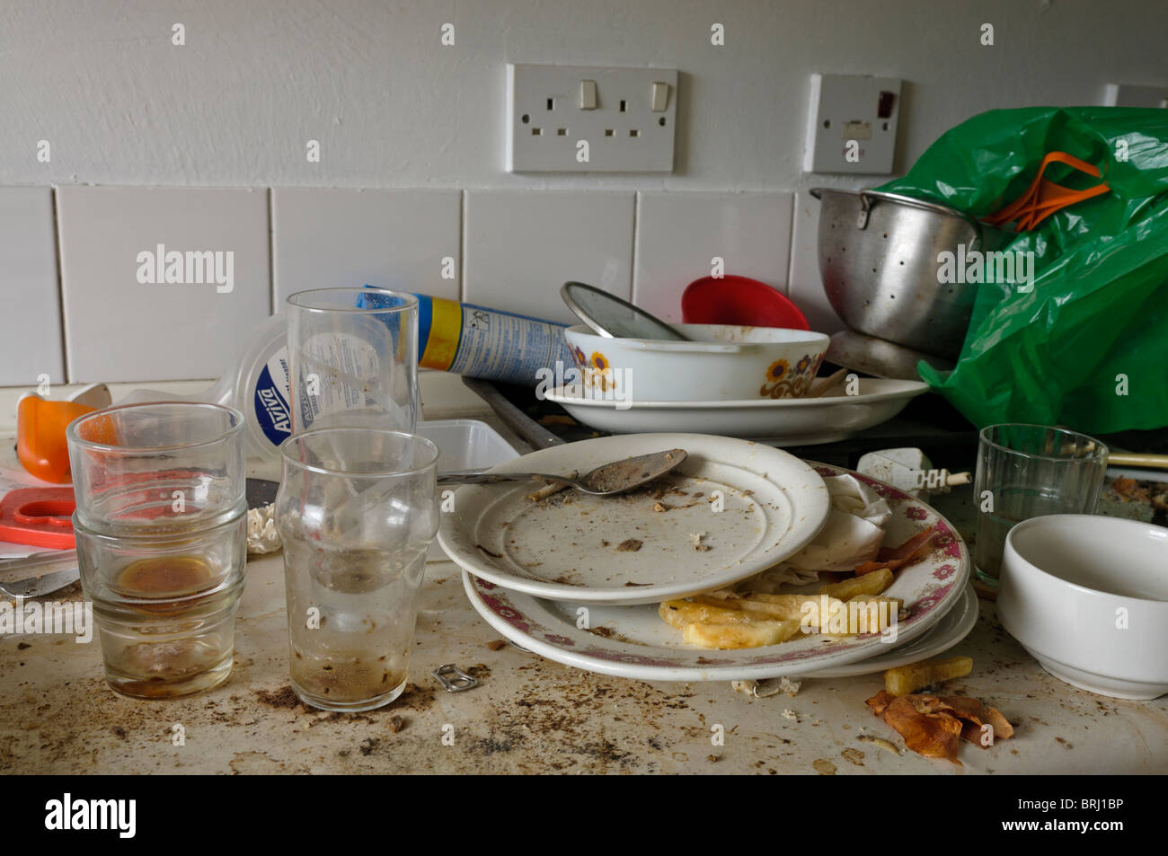 Molto piatti sporchi su una sporca del piano cucina Foto Stock