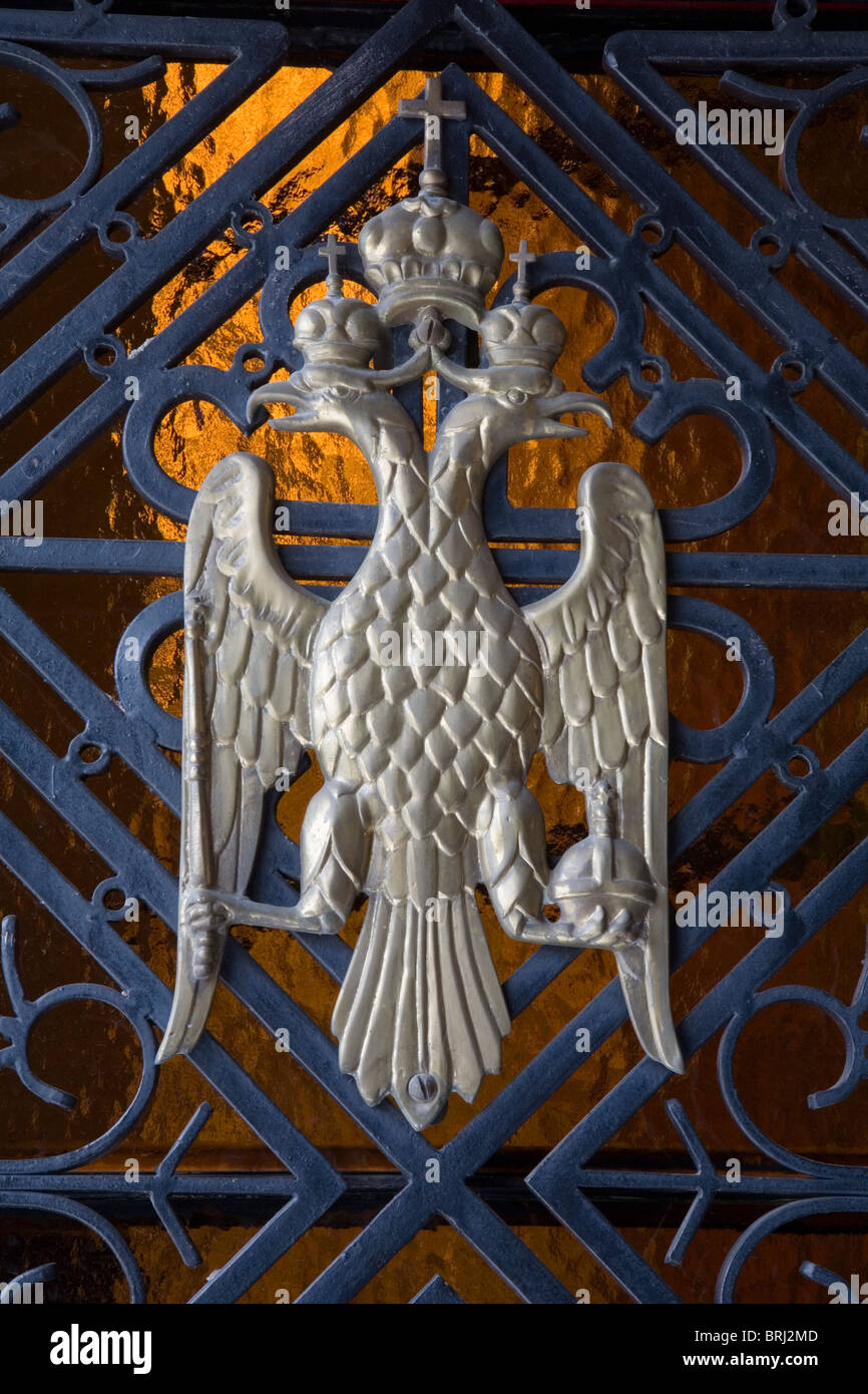 Ferro metallico rame DOUBLE HEADED EAGLE indossando la corona croce porta simbolo Chiesa Cristiana dominante unito mace tenere in ottone Foto Stock