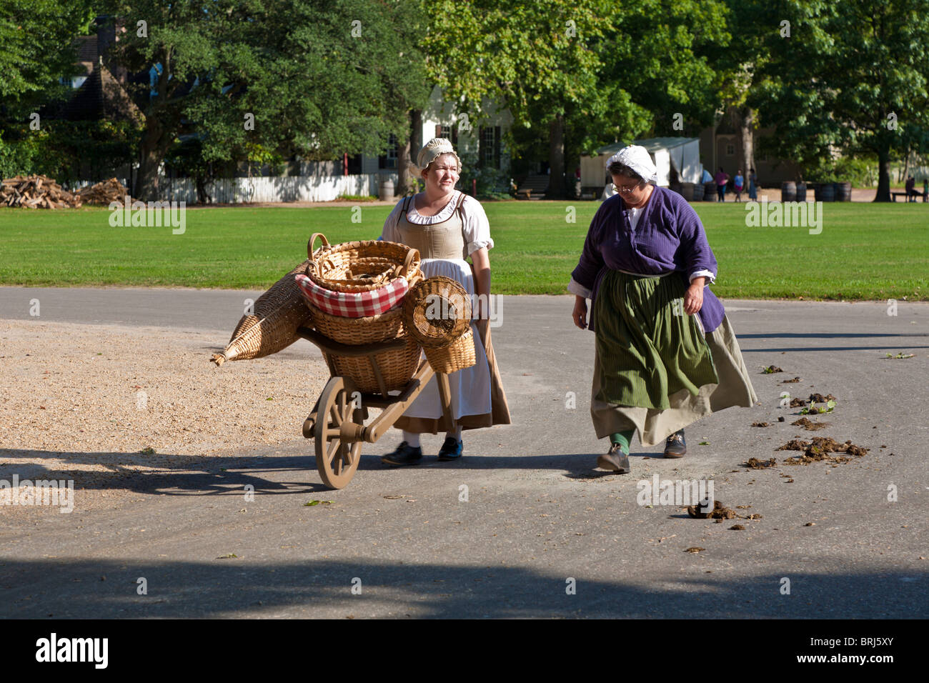 Cesto tessuto maker nel periodo abbigliamento a piedi sulla strada di Colonial Williamsburg, un museo vivente di storia di Williamsburg, VA Foto Stock