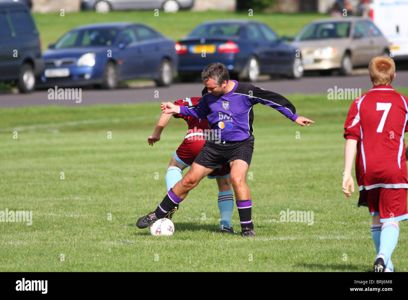 Inquadratura di un Downs Football League in Bristol su un sabato pomeriggio con un giocatore semplicemente facendo un importante affrontare. Foto Stock