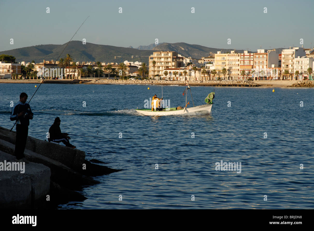 La pesca dalla scogliera, e piccole barche da pesca, Javea / Xabia, Provincia de Alicante, Comunidad Valenciana, Spagna Foto Stock