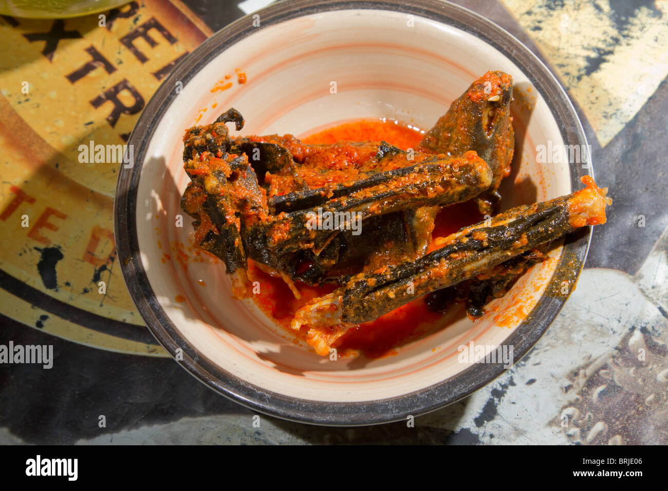 Carne di animali selvatici: Un pipipistrello di frutta africano cucinato di paglia (Eidolon helvum) in un ristorante rurale sulla strada, Ondo State, Nigeria. Foto Stock
