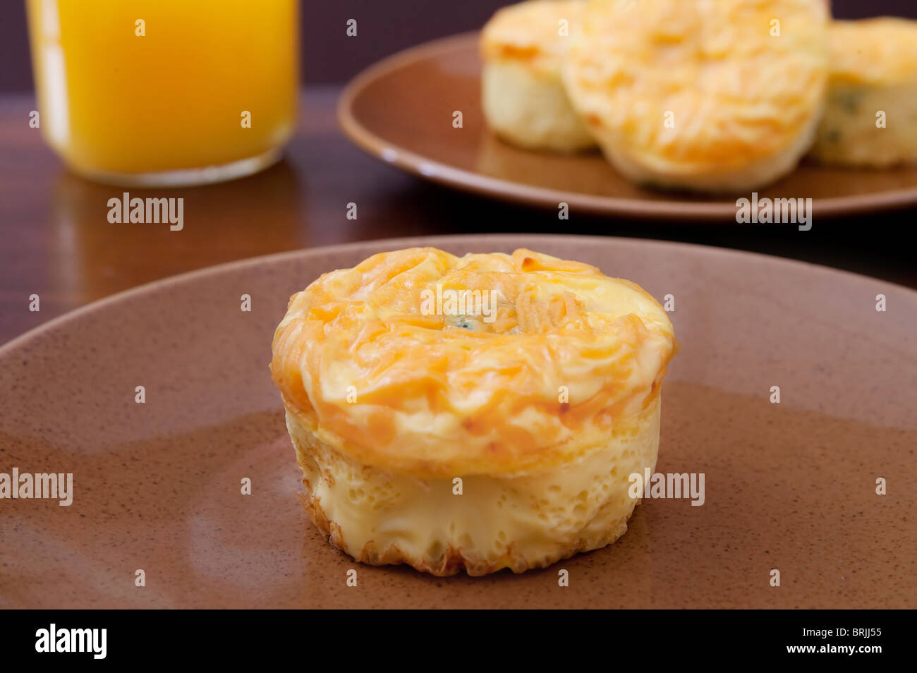 La colazione piatto di broccoli frittata muffin e fettine di arancia su una piastra marrone Foto Stock