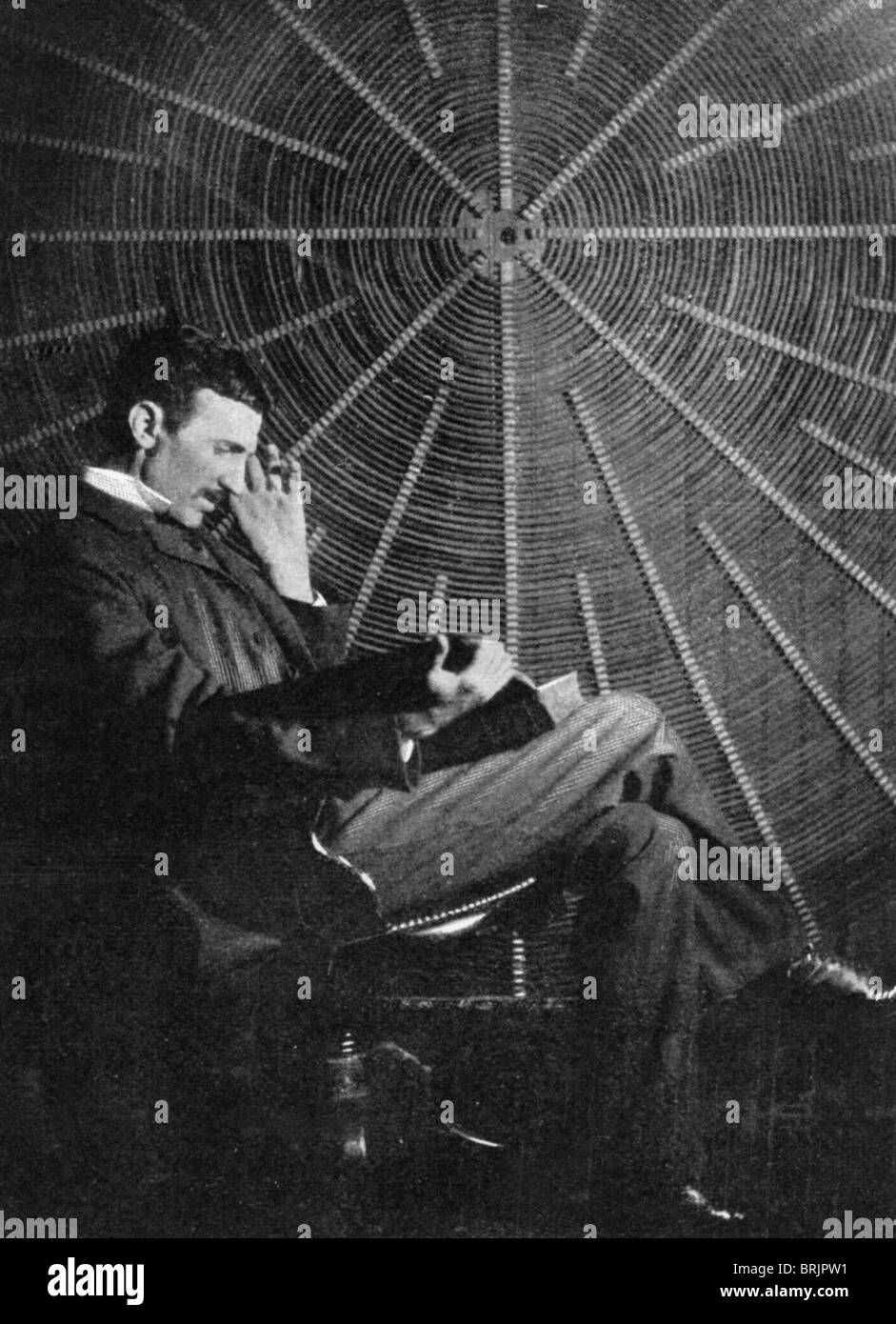 NIKOLA Tesla (1856-1943) inventore serbo davanti alla bobina a spirale del suo trasformatore ad alta frequenza - vedere la descrizione riportata di seguito Foto Stock