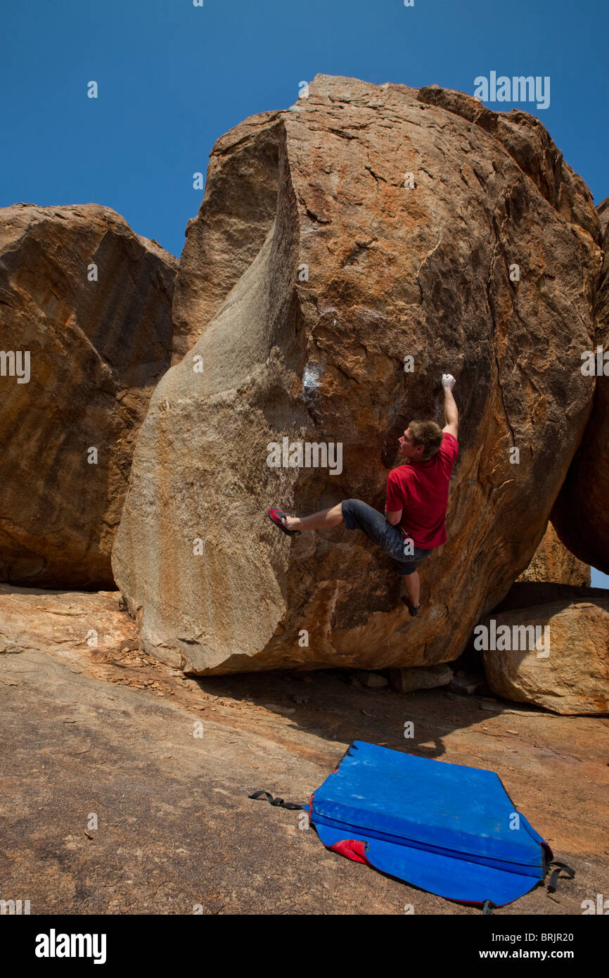 Caucasica scalatore maschio su un highball boulder in Hampi, India. Foto Stock