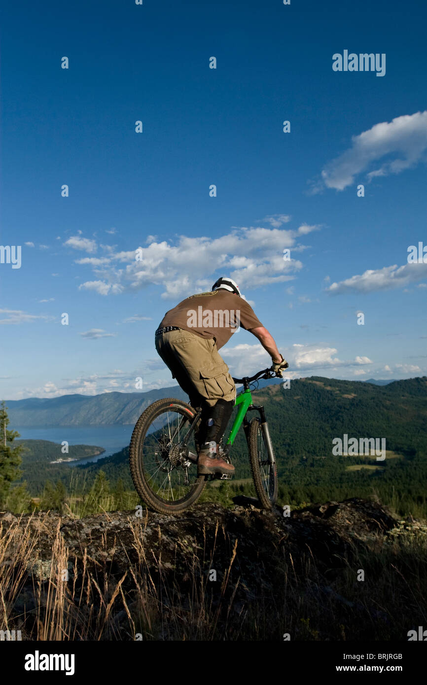 Giovane uomo mountain bike con il lago in background. Foto Stock